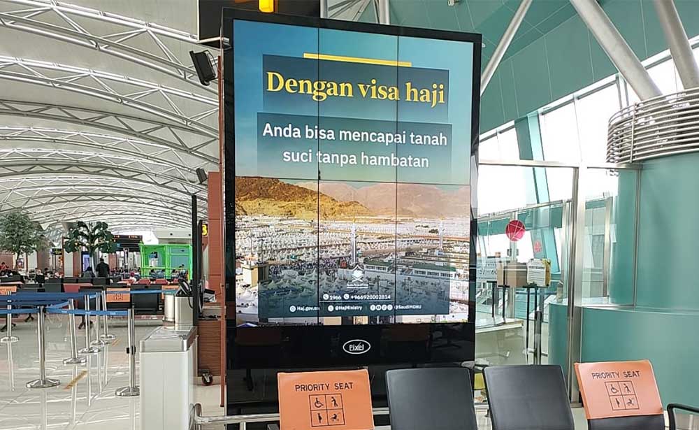 Saudi Hajj visa campaign on a portrait digital screen at a departure gate in Soekarno-Hatta International Airport, Jakarta, Indonesia