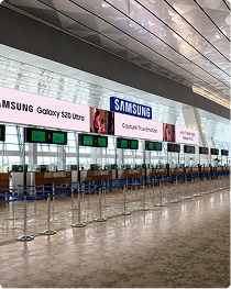 Samsung Galaxy S20 Ultra ads on digital screens above an airport check-in hall