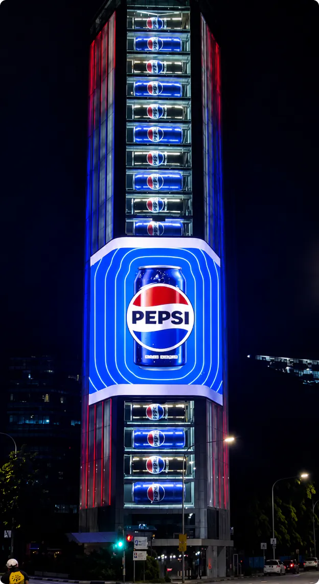 Pepsi ad on a vertical LED screen wrapping a high-rise building at night